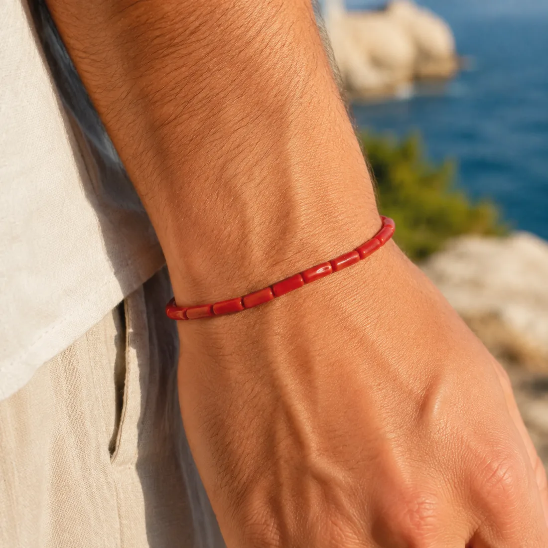 Bracelet Sirocco porté face à la mer — bijou en corail rouge unisexe AMAYAS